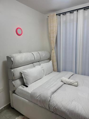 a white bed in a room with a window at Neriah Paradise in Gatunga