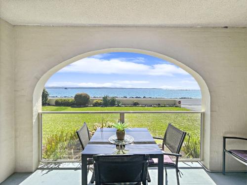 a dining room table with a view of the ocean at Beachside Apartment Overlooking Caseys Beach in Batehaven