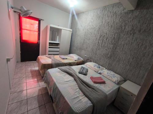 two beds in a hotel room with a red light at ADE Coj 23 LT 4 Ap102 in Brasília