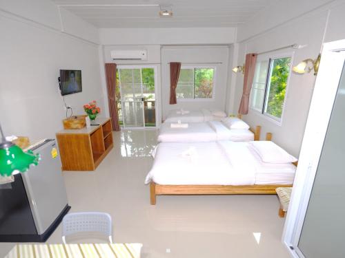 a bedroom with two beds and a television in it at Baan Bangrak Residence in Trang