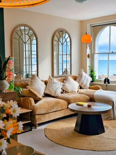 a living room with a couch and a table at Ocean Whisper - 2 Bedroom Sea Front Apartment in Folkestone