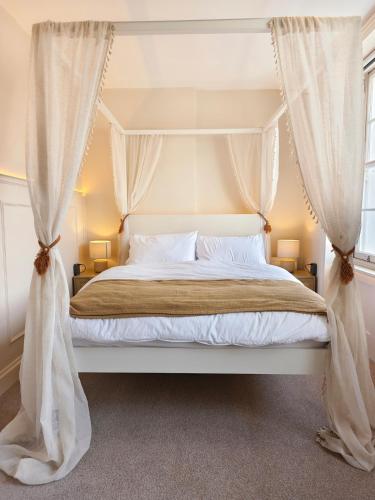 a bedroom with a canopy bed with curtains at Ocean Whisper - 2 Bedroom Sea Front Apartment in Folkestone
