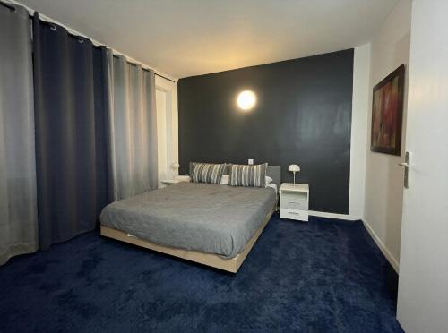 a bedroom with a bed and a black wall at Hôtel La Palmeraie in Toulouse