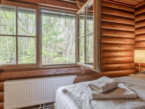 a bedroom with wooden walls and a bed with windows at im Brixental II in Wörgl