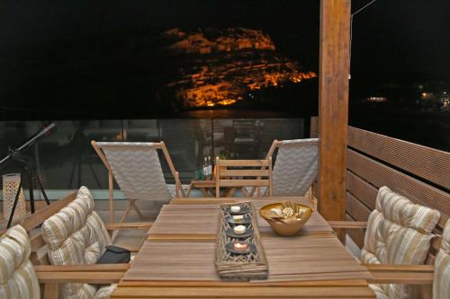 a wooden table and chairs on a balcony with a view at Matala Caves in Matala