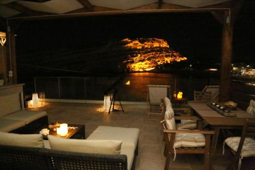 a patio with a view of a mountain at night at Matala Caves in Matala