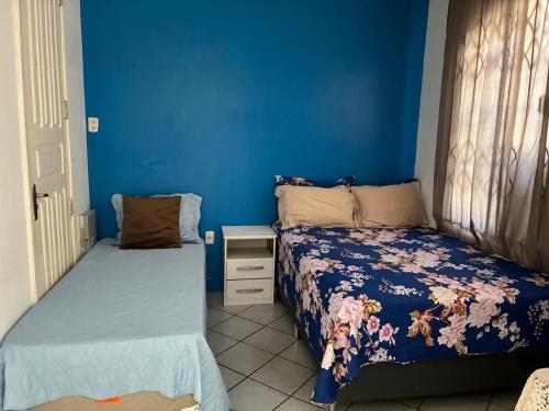 a bedroom with two beds and a blue wall at Casa Nossa Senhora de Nazaré 2 in Belém