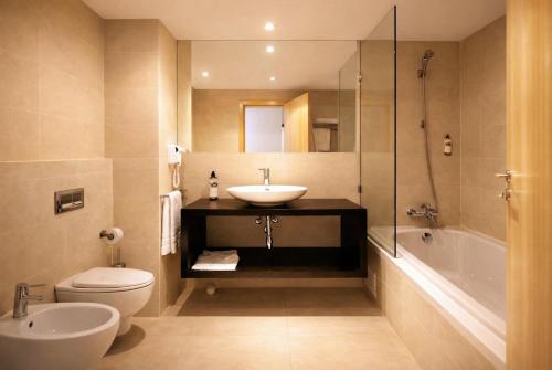 a bathroom with a sink and a toilet and a shower at The Lisbonaire Apartments in Lisbon