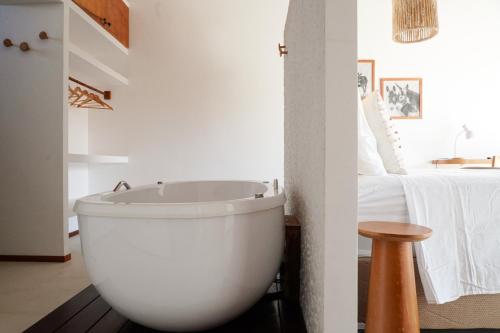 a white bath tub in a room with a bed at Villa Conduru III Kite House Preá 100m from Beach in Cruz