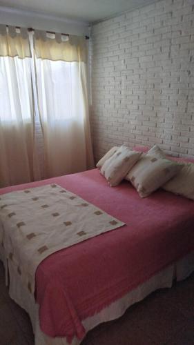 a bedroom with a large bed with a brick wall at Casita de descanso in Pueblo Esther