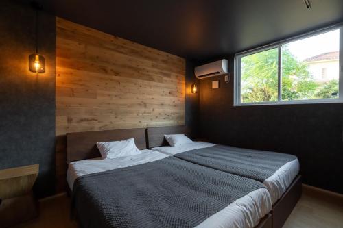 a bedroom with a large bed and a window at villa vacances hamanako in Hamamatsu