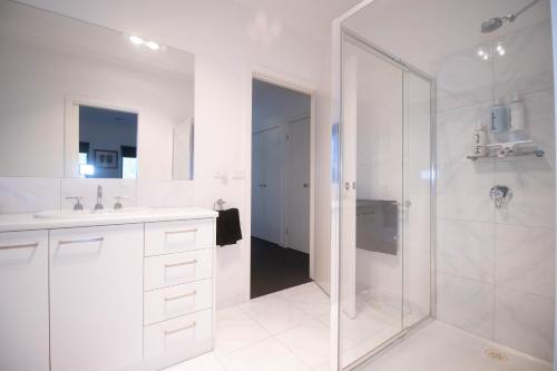 a white bathroom with a shower and a sink at Canvas & Comfort Peaceful Ballarat Base in Wendouree