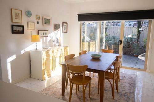 a kitchen and dining room with a wooden table and chairs at Canvas & Comfort Peaceful Ballarat Base in Wendouree