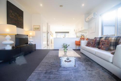 a living room with a couch and a tv at Canvas & Comfort Peaceful Ballarat Base in Wendouree