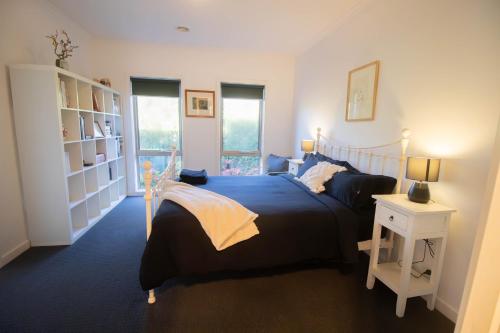 a bedroom with a large bed and a night stand at Canvas & Comfort Peaceful Ballarat Base in Wendouree