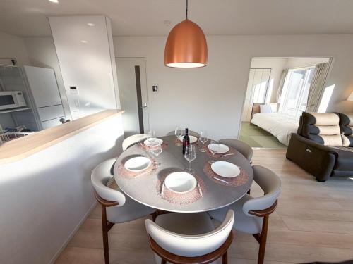 a dining room with a table and chairs in a room at 熊本熊猫基地セミコンハブ Kumamoto Panda Base Semicon Hub in Ozu