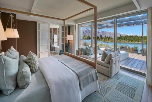 a bedroom with a large bed and a large window at ROKI Collection in Queenstown