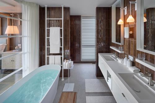 a bathroom with two sinks and a bath tub at ROKI Collection in Queenstown