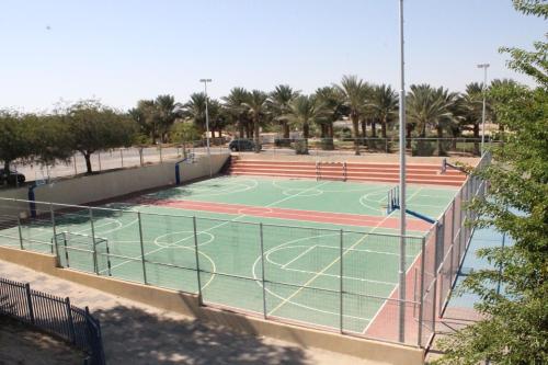 a tennis court in a park with palm trees at Hahan Guest House in the Arava in H̱aẕeva