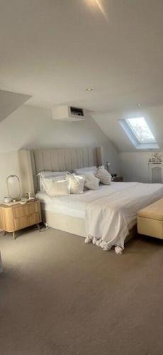 a bedroom with a large white bed with a window at Layla Grove in Grove Park