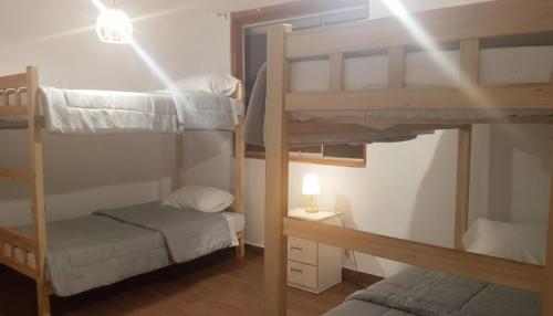 a room with two bunk beds and a lamp at Casa Blanca Andina in Cajamarca