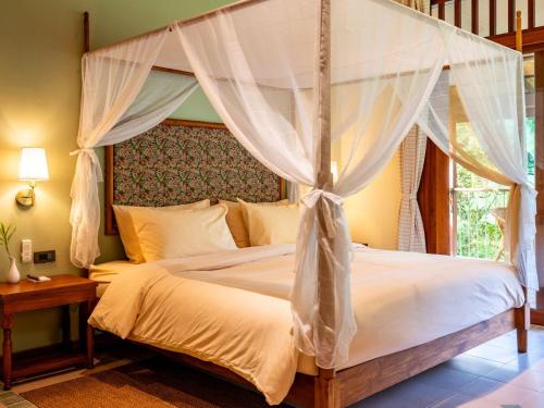 a bedroom with a bed with a canopy at Lost Horizon Resort - Khao Sok in Khao Sok National Park