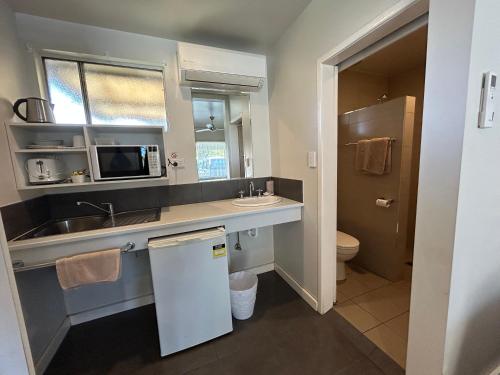 a small bathroom with a sink and a toilet at Tweed River Motel in Murwillumbah