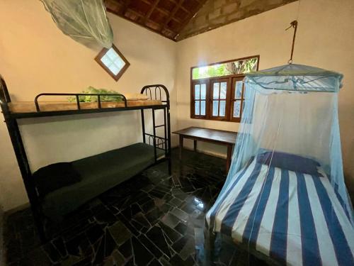 a room with two bunk beds and a table at Farmhouse Homestay in Negombo
