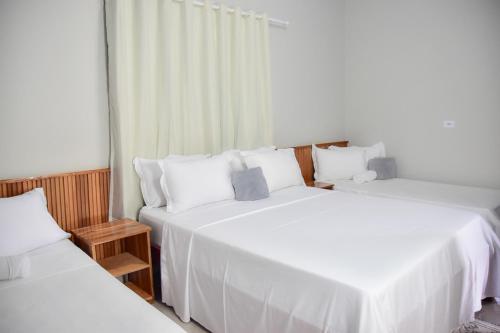 two beds in a room with white sheets at casa completa Paraiso valle verde in Estivado