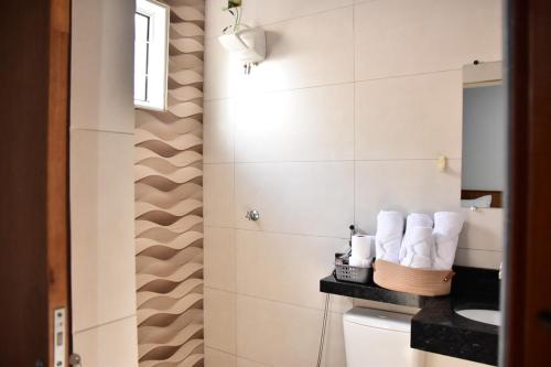 a bathroom with a sink and towels on a shelf at casa completa Paraiso valle verde in Estivado