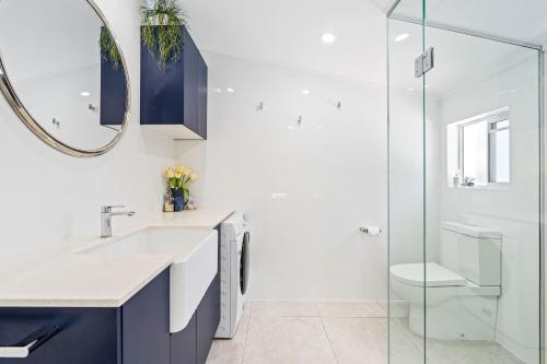 a bathroom with a sink and a mirror at Pet Friendly Beach House with pool - Sleeps 10 in Urangan