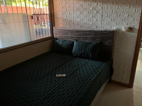 a bed sitting in a room next to a window at Complejos Residenciales Las Lomitas in San Lorenzo de la Frontera
