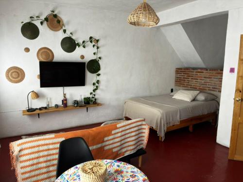 a bedroom with a bed and a tv and a table at Casa Roma in Taxco de Alarcón