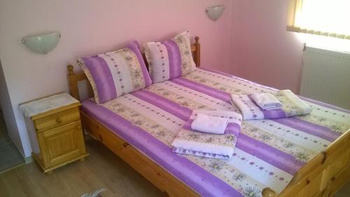 a bedroom with a bed with purple sheets and pillows at Villa Bulgarka in Divchovoto