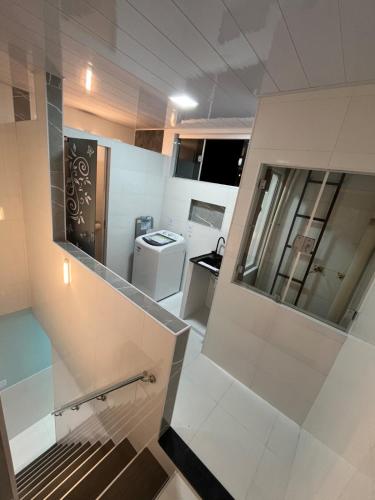 a small kitchen with white tile walls and a staircase at APART HOTEL Wm in Belém