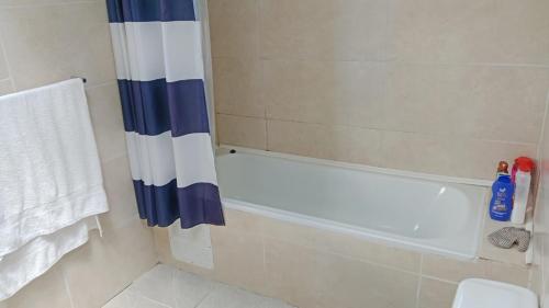 a bathroom with a shower curtain and a bath tub at Hospedaje Campestre Ranco Naturaleza - Desayuno incluido in Lago Ranco