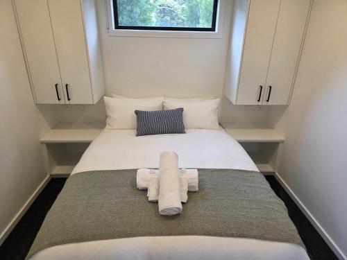a small room with a bed with towels on it at Sale Caravan Park in Sale