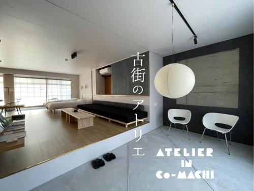 a living room with a black couch and chairs at 古街のアトリエ in Utazu