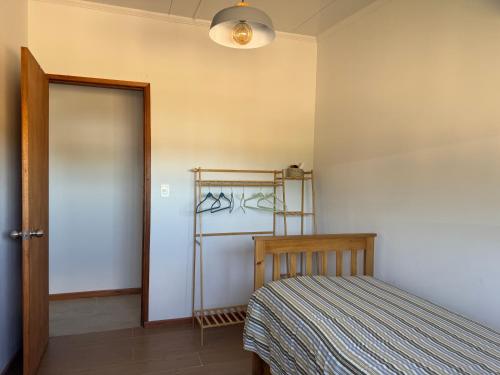 a bedroom with a bed and a door and a lamp at Refugio del Indalo in Termas de Guaviyú