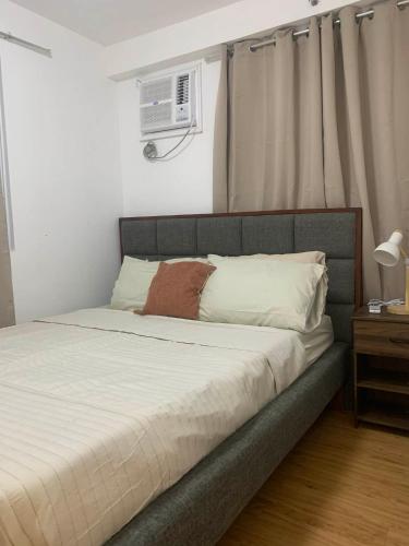 a bedroom with a large bed with a white bedspread at 1 Bedroom Arezzo Condotel in Davao City