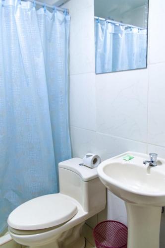 a bathroom with a white toilet and a sink at AMARU Palace in Machu Picchu