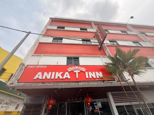 a building with a red and white sign on it at Anika Inn Kluang in Kluang