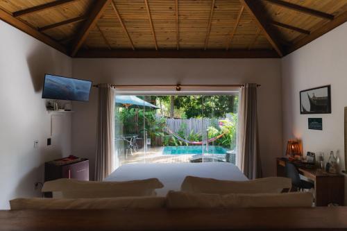 a bedroom with a bed and a view of a pool at LAUS Bangalôs Experience - Piscina Privativa - Praia de Algodões - Península de Maraú - Bahia in Praia dos Algodões
