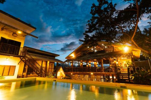 a resort with a swimming pool in front of a building at The Shack Hideaway by Mayumi Resorts in Mabini