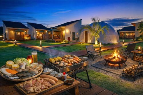 an outdoor entertaining area with a table of food and a fire pit at Ducale Garden Hotel Kujukuri in Kujukuri