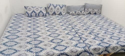 a blue and white quilt on a bed with pillows at Hari Sharnam Residency in Mathura