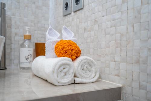 a pile of towels on a counter in a bathroom at Zen Villa - Central Canggu in Canggu