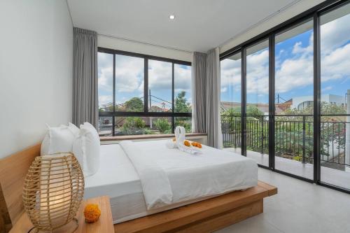 a bedroom with a bed and large windows at Zen Villa - Central Canggu in Canggu