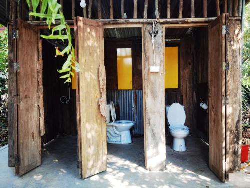 an open door to a bathroom with two toilets at ไทไอดิน in Ban Khui Khwang