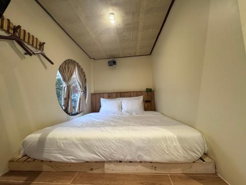 a bedroom with a white bed with a mirror at The Hue Verandah in Thôn Trường Giang